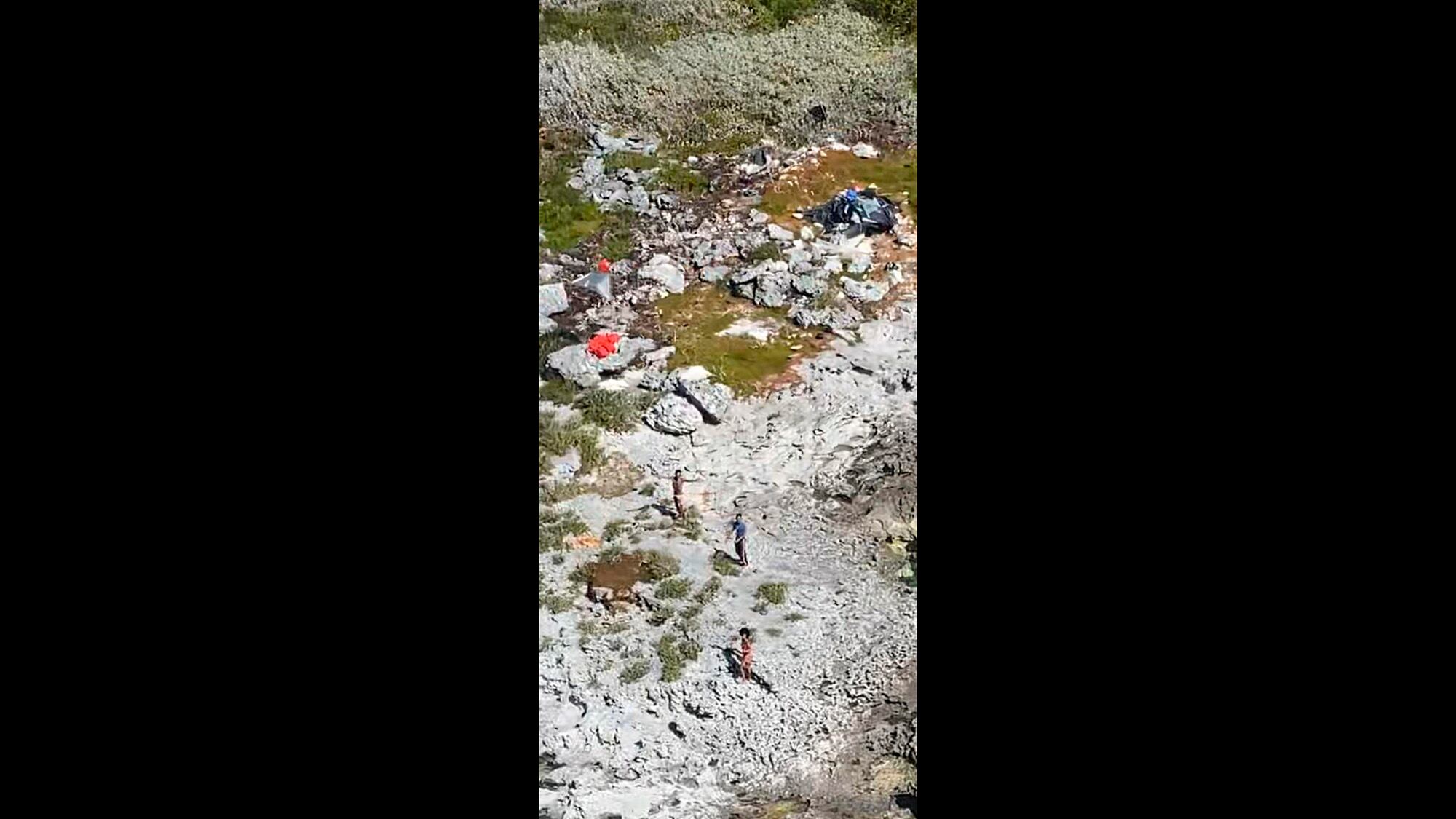 This photo provided by the U.S. Coast Guard shows three Cuban nationals being rescued from a deserted island between Florida and Cuba, Monday, Feb. 9, 2021.