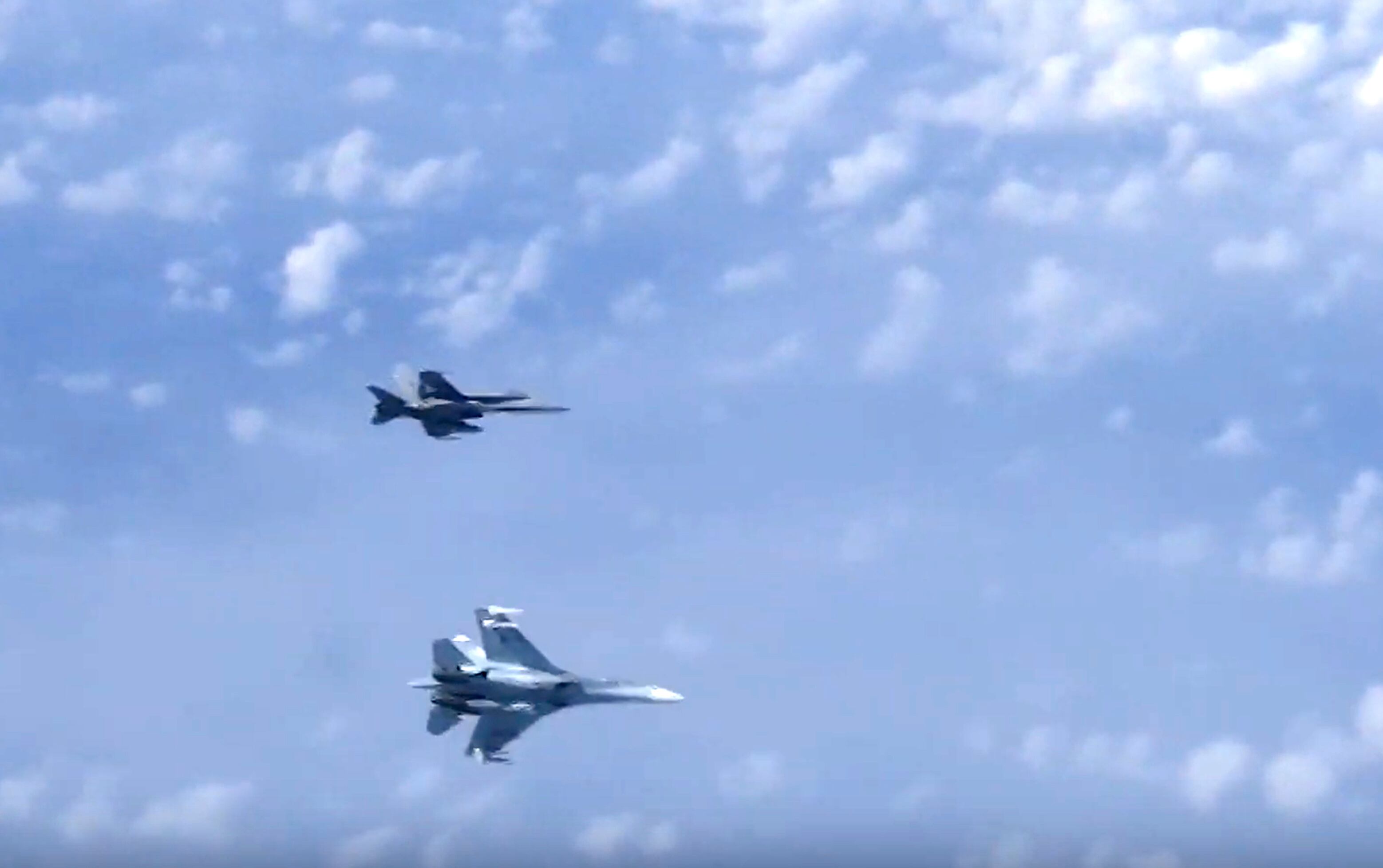 In this video grab taken from a footage on Aug. 13, 2019, and distributed by Russian Defense Ministry Press Service, a Russian air force's Su-27 fighter jet, bottom, maneuvers to ward off a NATO F-18 warplane over the Baltic Sea.