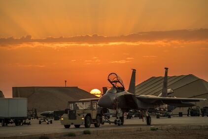 Airmen assigned to the 332nd Air Expeditionary Wing tow an F-15E Strike Eagle on April 15, 2020, at an undisclosed location in Southwest Asia.