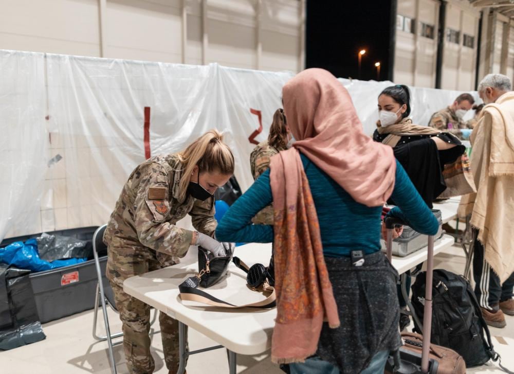 A U.S. Air Force airman assigned to the 726th Air Mobility Squadron performs security checks on luggage during the outbound passenger processing at Hangar 5 at Ramstein Air Base, Germany, Sept. 5, 2021. The 521st Air Mobility Operations Wing shifted 78 airmen from various AMOW locations to support evacuation operations. (Tech. Sgt. Aaron Luetzen/Air Force)