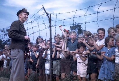 Col. Gail Halvorsen, the "Berlin Candy Bomber," greets children at a barbed wire fence at Tempelhof Airport in Berlin, 1948.