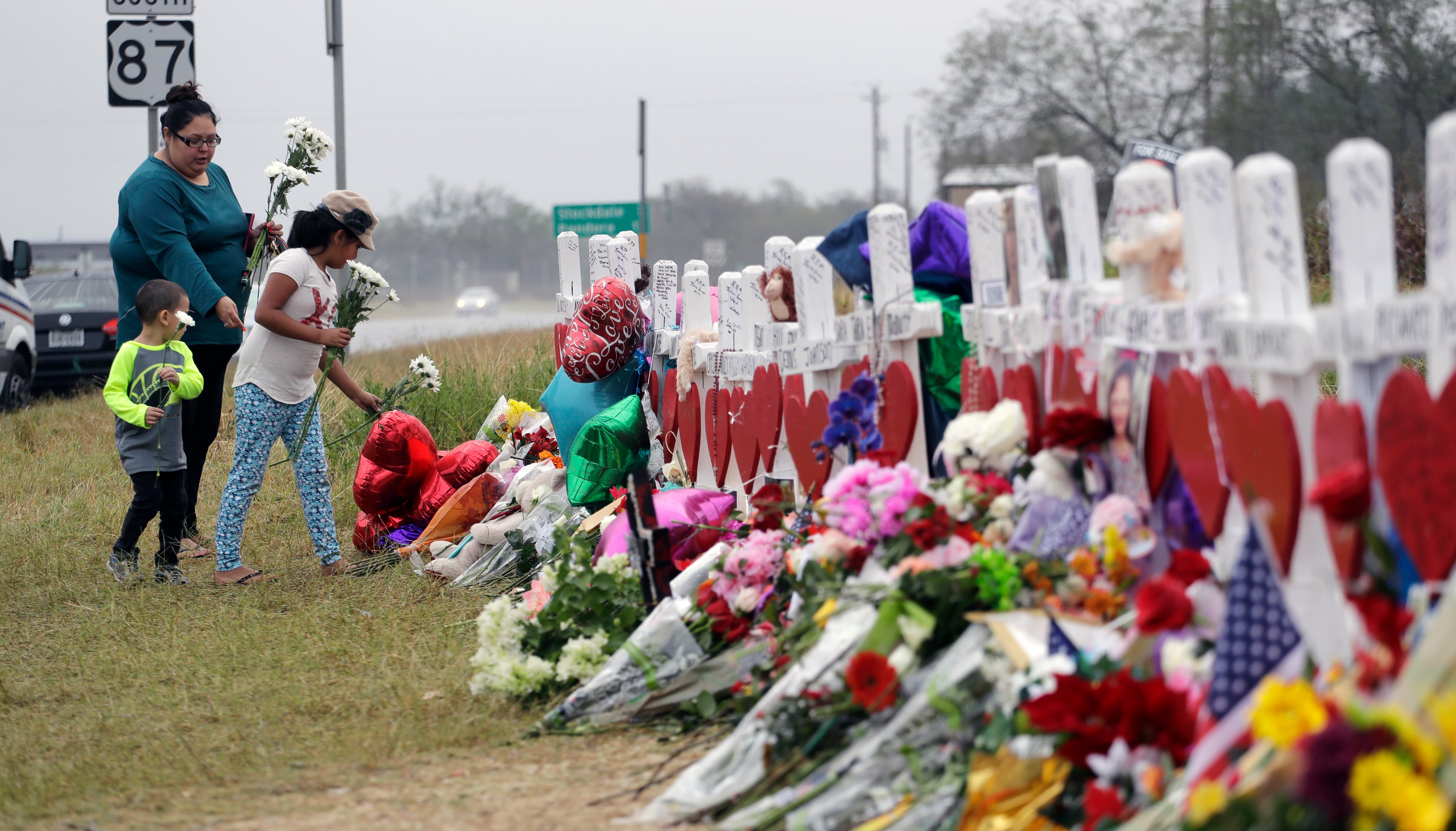 Christina Osborn and her children Alexander Osborn and Bella Araiza visit a makeshift memorial for the victims of the shooting at Sutherland Springs Baptist Church, Nov. 12, 2017, in Sutherland Springs, Texas.