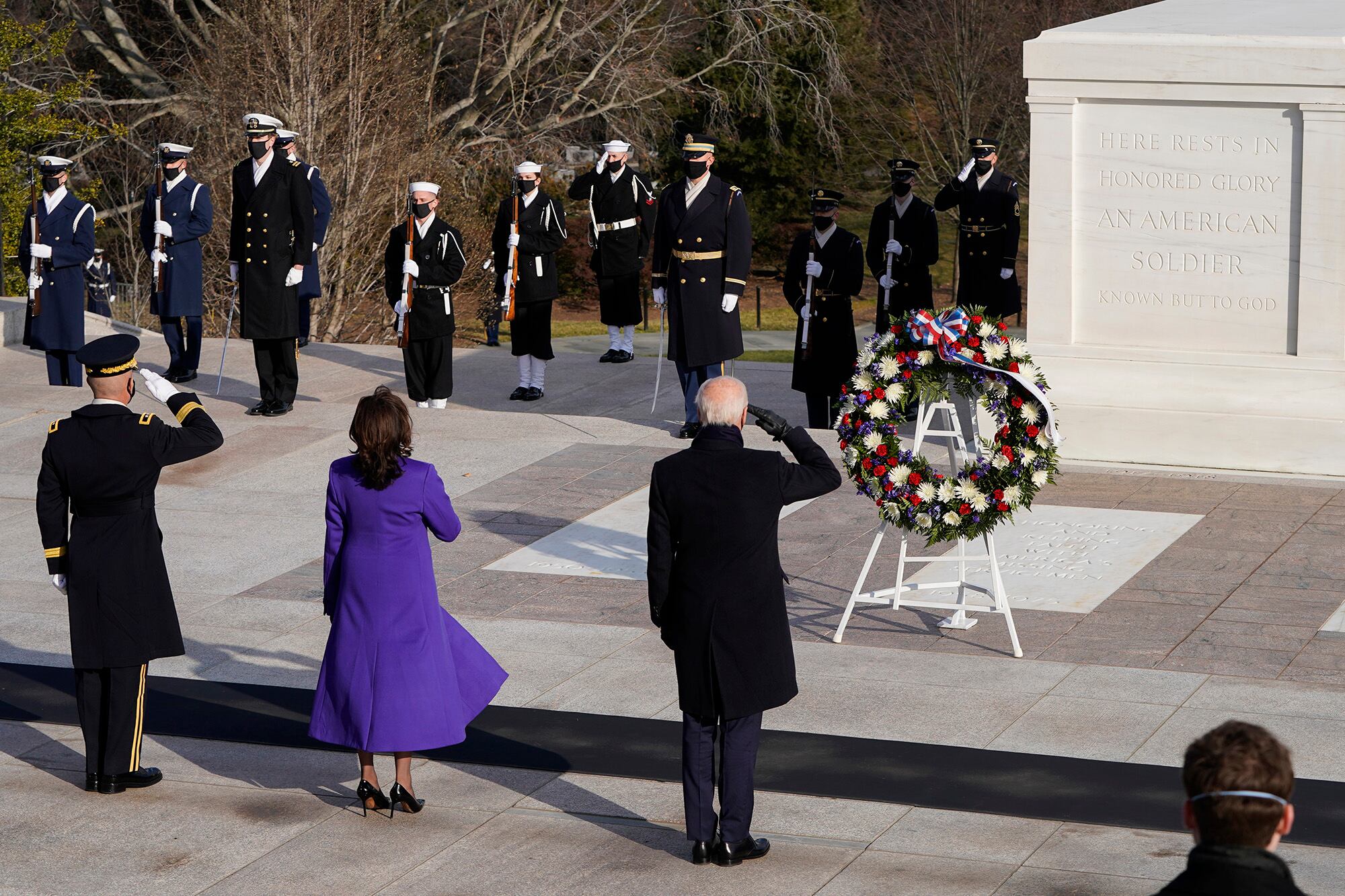 President Joe Biden, center, Vice President Kamala Harris, and Maj. Gen. Omar J. Jones salute at the Tomb of the Unknown Soldier at the Arlington National Cemetery on Jan. 20, 2021, in Arlington, Va.