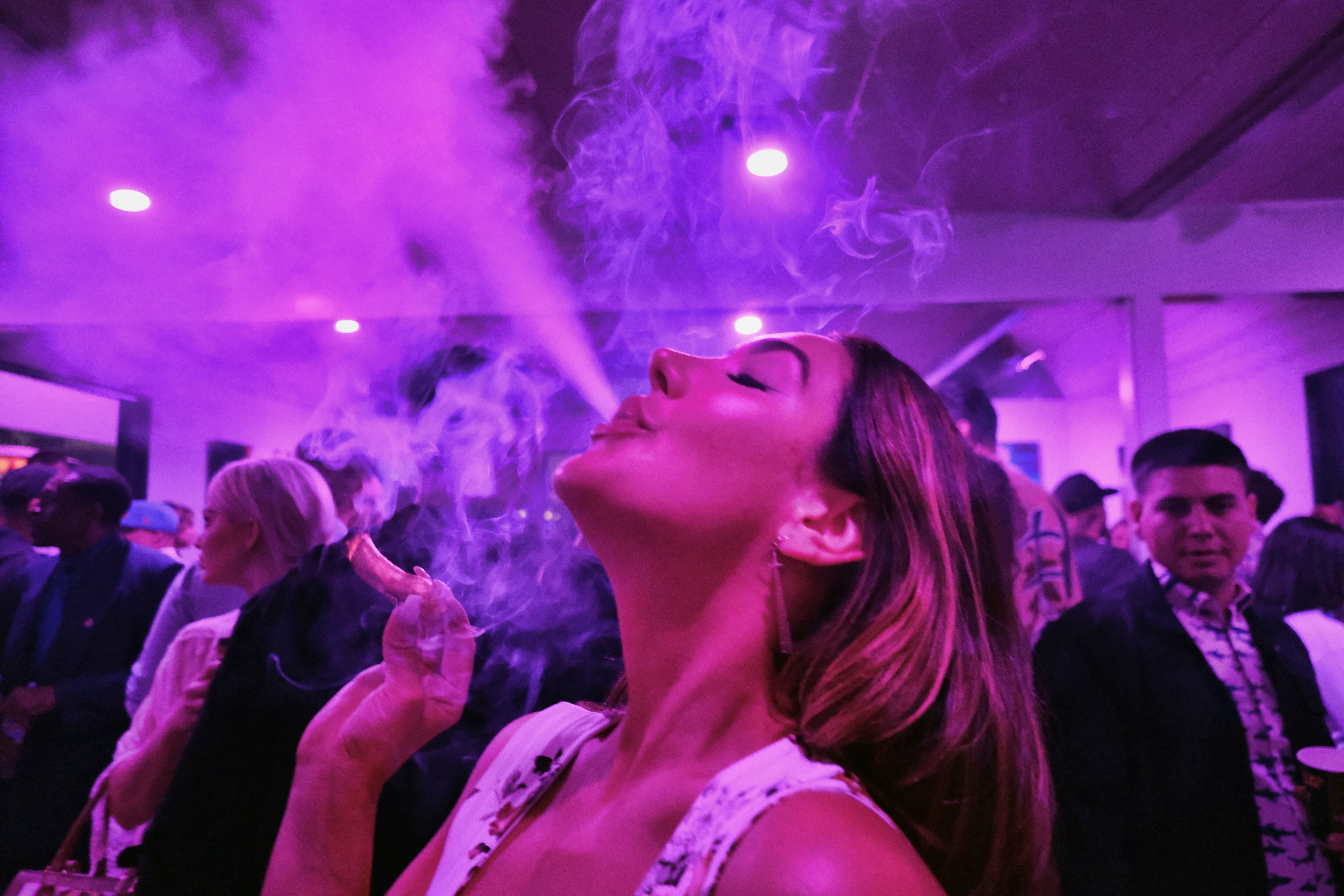 A guest takes a puff from a marijuana cigarette at the Sensi Magazine party celebrating the 4/20 holiday in the Bel Air section of Los Angeles on April 20, 2019. (Richard Vogel/AP)