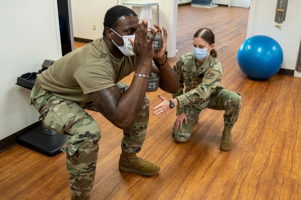 Maj. Kristin Stanford, 15th Medical Operational Medical Readiness Squadron physical therapist and nutritional medicine, demonstrates a treatment on Tech. Sgt. Caleb Chandler, 15th OMRS physical therapy flight chief, for an injury at Joint Base Pearl Harbor-Hickam, Hawaii, April 19, 2022. (Airman 1st Class Makensie Cooper/Air Force)