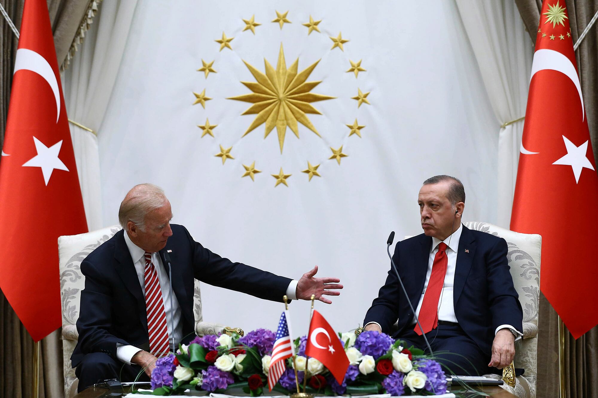 Then-Vice President Joe Biden, left, speaks with Turkish President Recep Tayyip Erdogan as they sit in front of flags for Turkey.