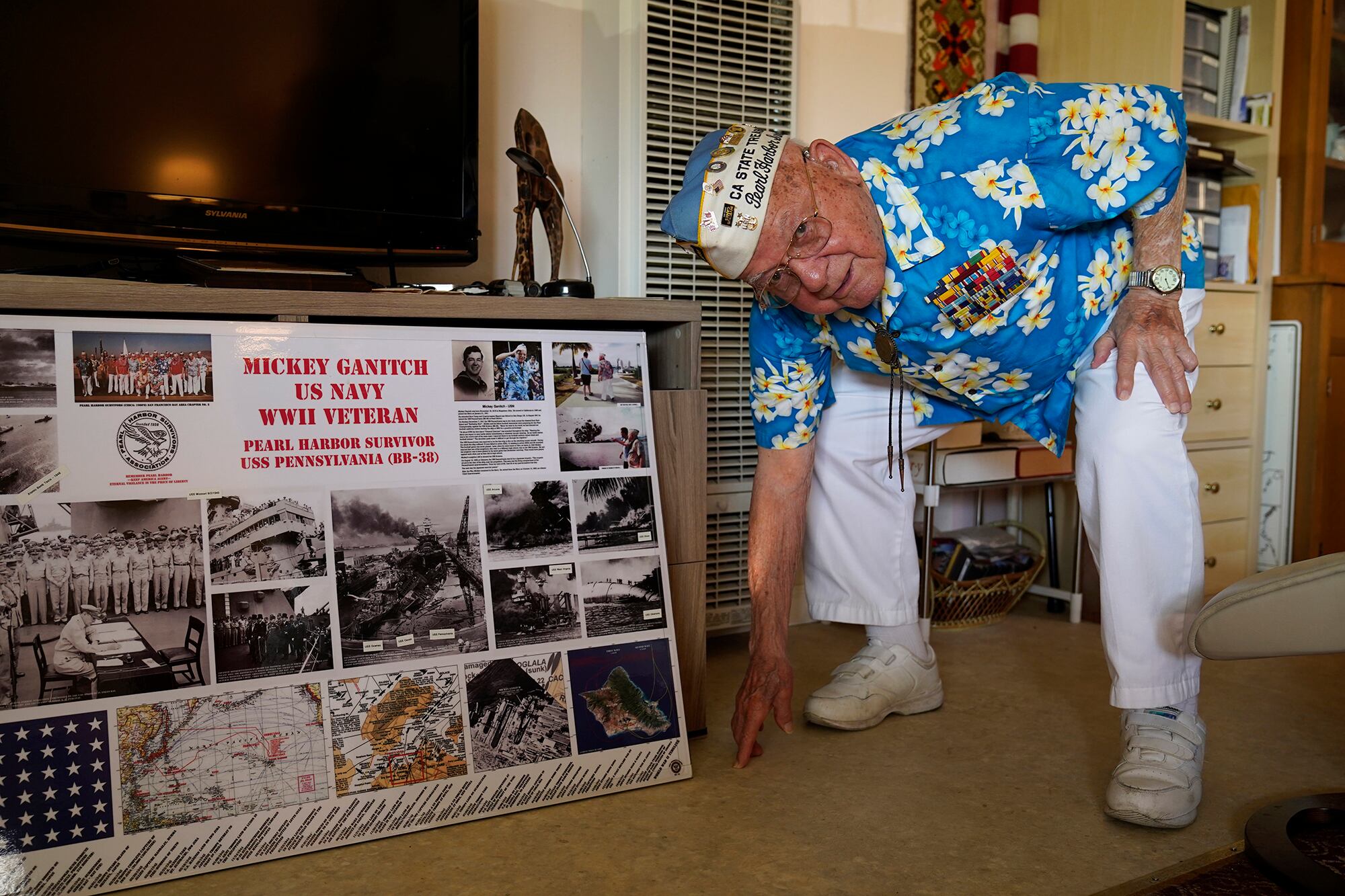 Mickey Ganitch, a 101-year-old survivor of the attack on Pearl Harbor, drops down to display his football stance in the living room of his home in San Leandro, Calif., Nov. 20, 2020.