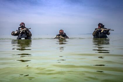 U.S. Marines patrol through water during a Marine Corps Combat Diving Supervisors Course on Camp Schwab, Okinawa, Japan, May 20, 2020.