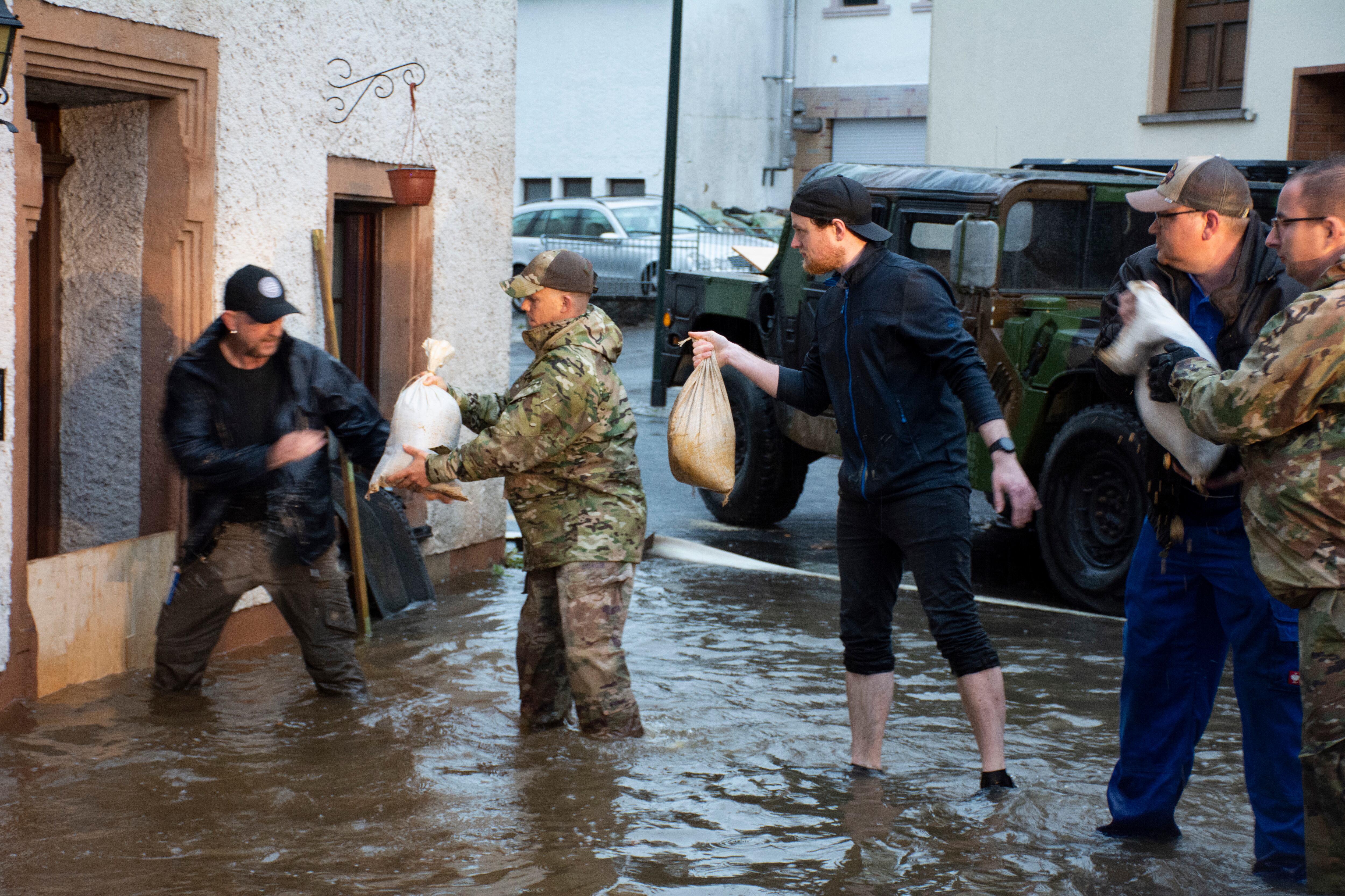 Members from the 52nd Civil Engineer Squadron from Spangdahlem Air Base, Germany, work with German first responders and community members to lay sandbags in the town of Binsfeld, Germany, July 14, 2021. The 52 CES was able to fill and deliver around 1,800 sandbags to help protect homes and businesses in the communities of Binsfeld and Neiderkail after heavy rainfall caused severe flooding in the region. (Tech. Sgt. Warren Spearman/Air Force photo)