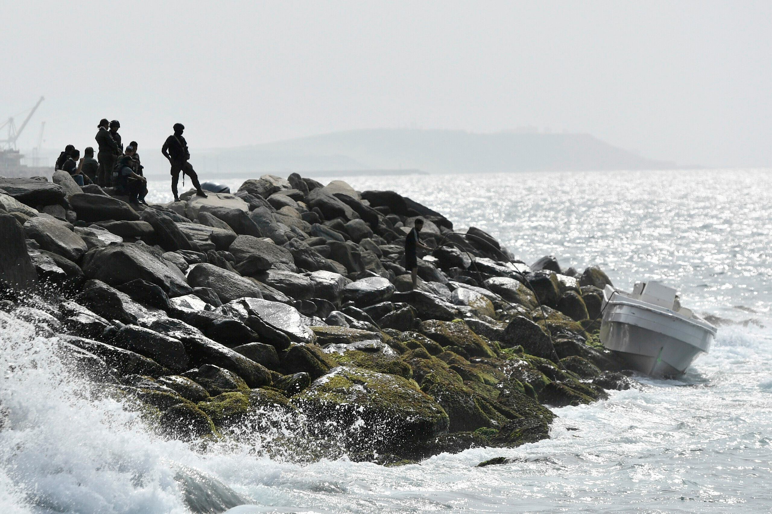 Security forces guard the shore area and a boat in which authorities claim a group of armed men landed in the port city of La Guaira, Venezuela