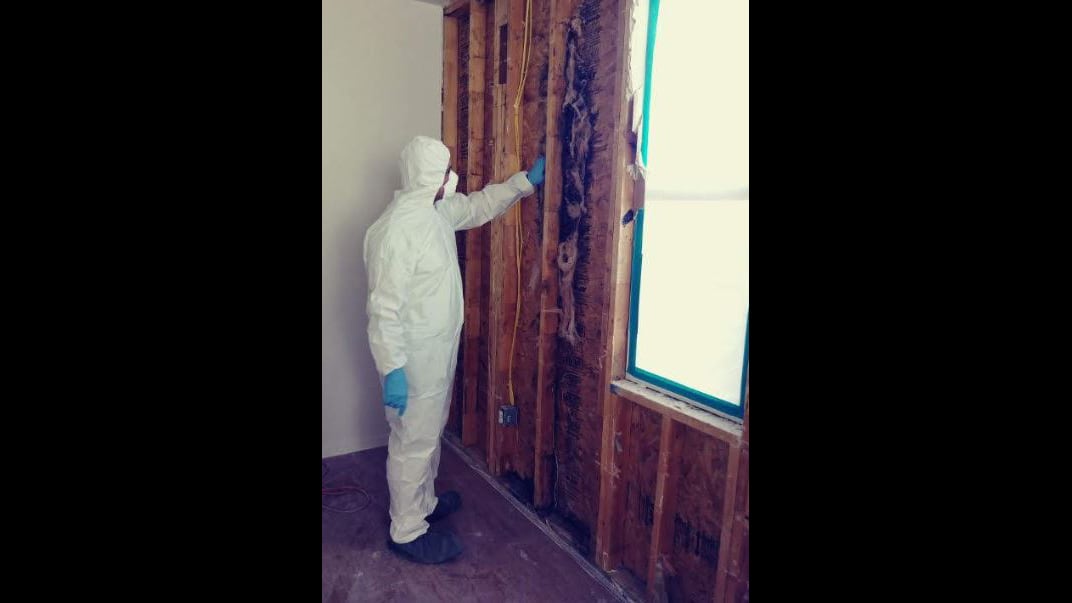 Sgt. 1st Class Jesus Joseph Brown dons a hazmat suit to look at his house at Fort Hood after it was opened up for mold repairs.