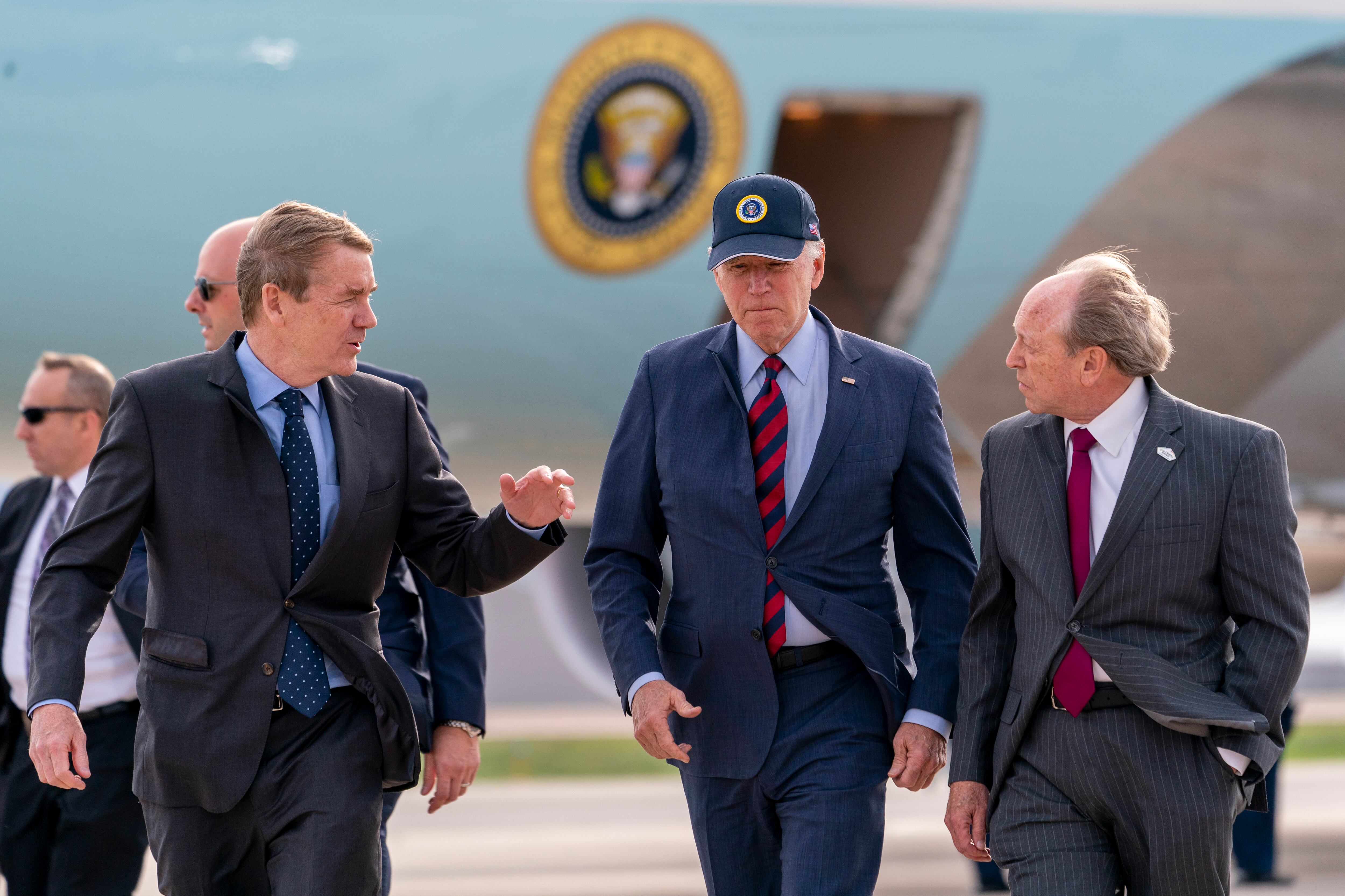 Air Force One is visible as President Joe Biden, center, speaks with by Sen. Michael Bennet, D-Colo., left, and Colorado Springs Mayor John Suthers, right, as he arrives at Peterson Space Force Base in Colorado Springs, Colo., Wednesday, May 31, 2023.