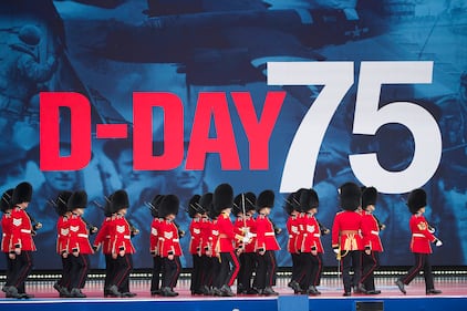 An honor guard marches on stage during a ceremony to mark the 75th Anniversary of D-Day,