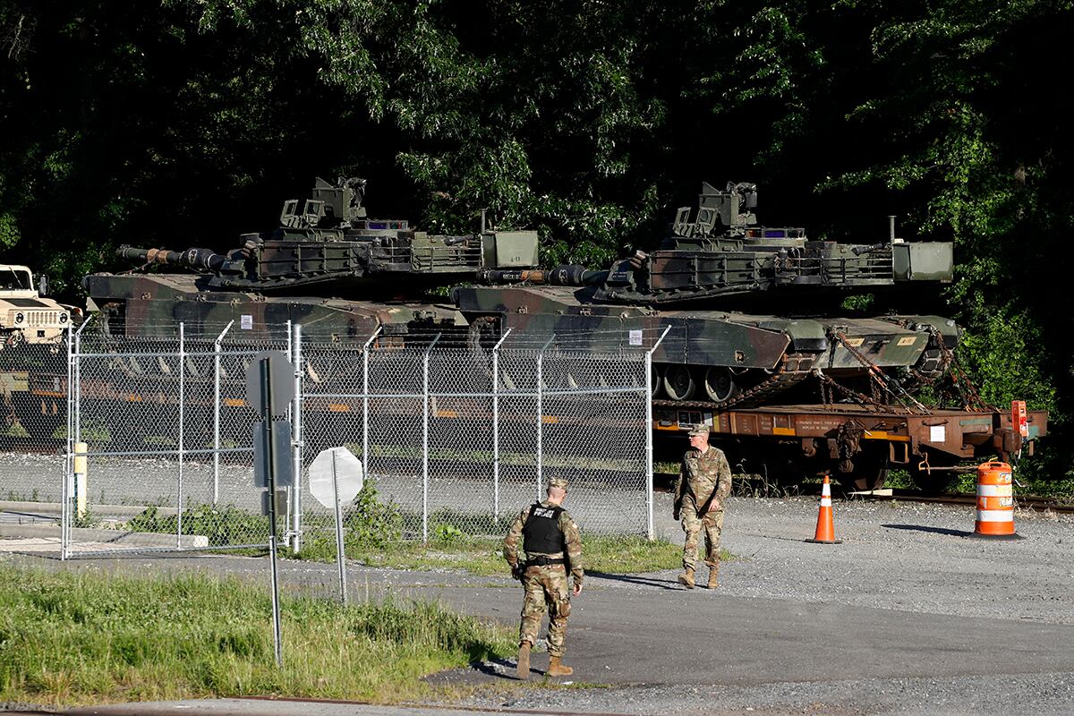 Military police walk near Abrams tanks on a flat car in a rail yard, Monday, July 1, 2019, in Washington, ahead of a Fourth of July celebration that President Donald Trump says will include military hardware.