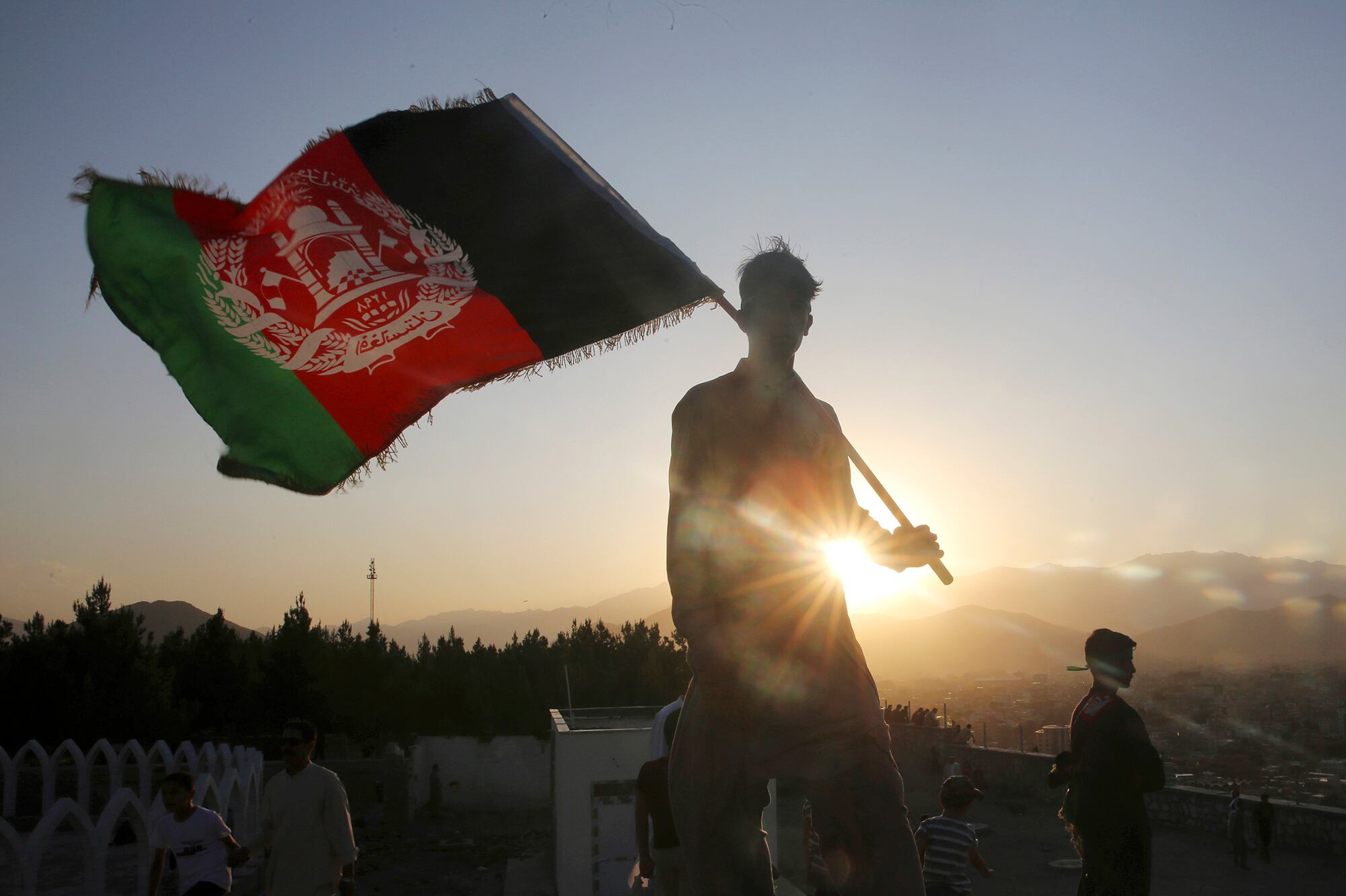 In this Aug. 19, 2019, file photo, a man waves an Afghan national flag during Independence Day celebrations in Kabul, Afghanistan