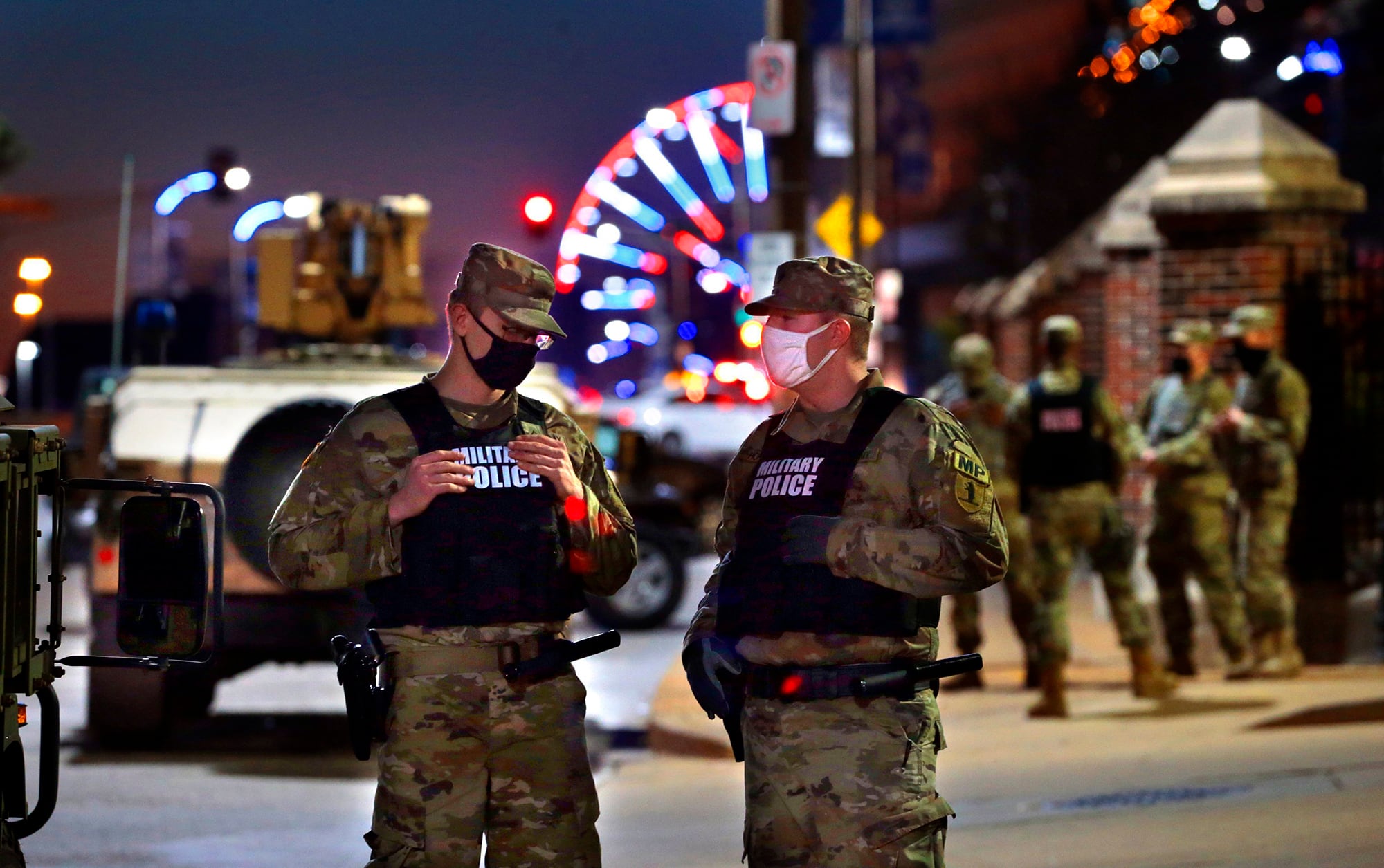 Members of the Missouri National Guard stand near the entry to the St. Louis City Hall parking lot Tuesday, Nov. 3, 2020, as Election Day comes to a close.