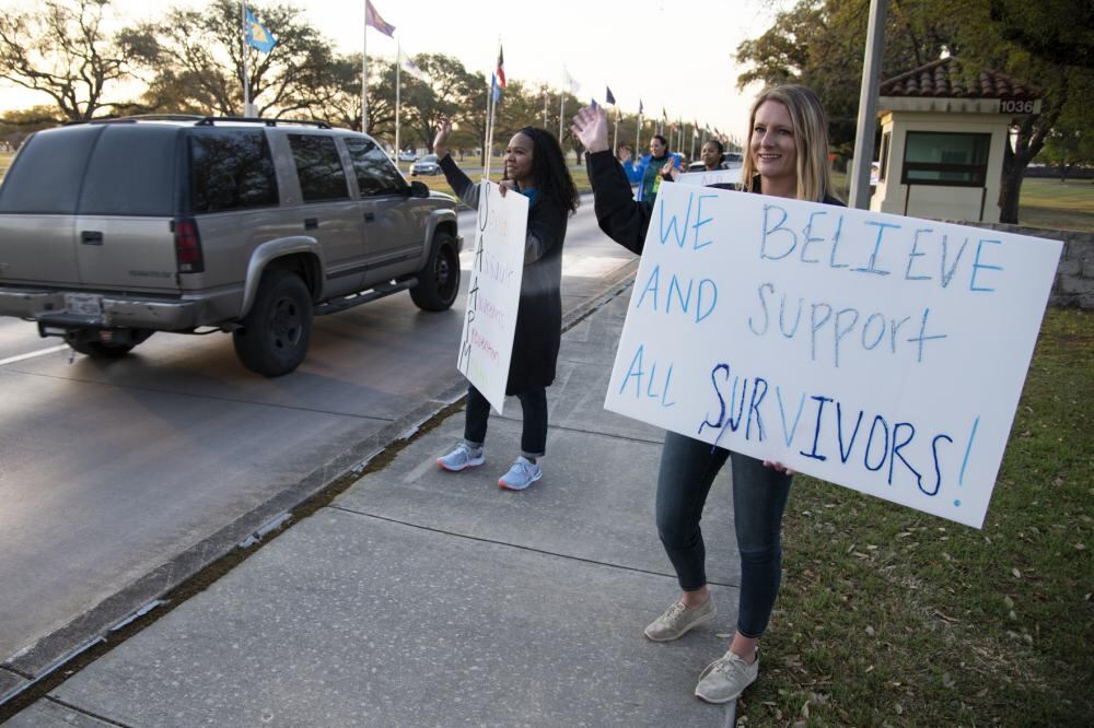 Felicia McCollum (right), 502nd Air Base Wing sexual assault prevention and response advocate programs director, and Dannielle Hutchins, 502nd Air Base Wing sexual assault response coordinator, wave to drivers during the “Stand Against Sexual Assault” drive-by campaign Apr. 1, 2022 at Joint Base San Antonio-Randolph, Texas. (Sean M. Worrell/Air Force)