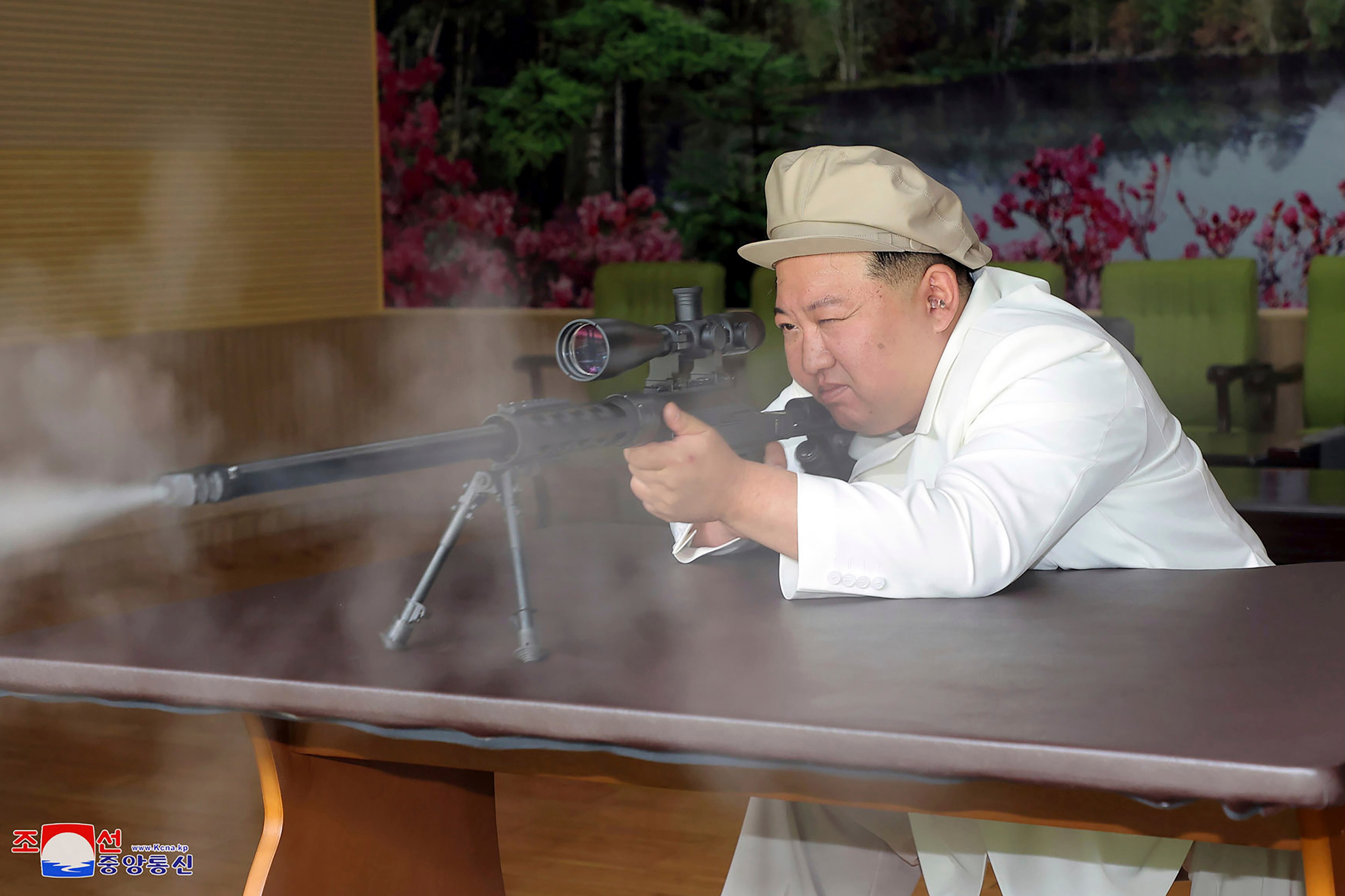 In this undated photo provided by the North Korean government, North Korean leader Kim Jong Un, right, holds a weapon during his three-day inspection from Aug. 3 until Aug. 5, 2023 at major munitions factories in North Korea.