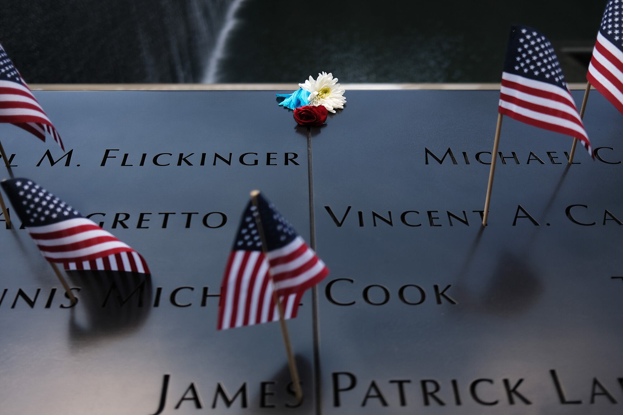 A flower is placed on a name at the 9/11 memorial plaza on the first day it reopened after closing for three months due to the coronavirus on on July 4, 2020, in New York City.