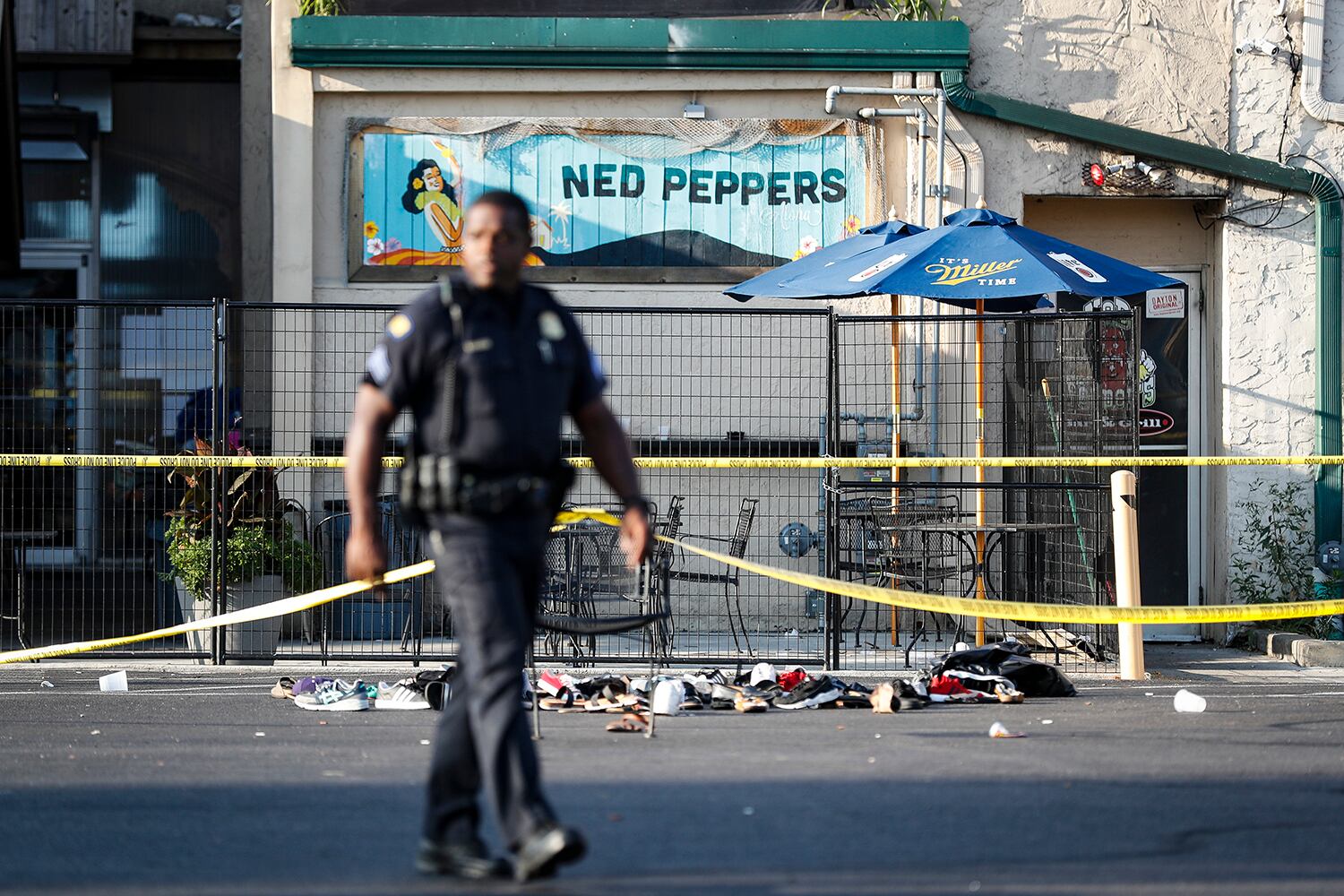 Shoes are piled outside the scene of a mass shooting including Ned Peppers bar, Sunday, Aug. 4, 2019, in Dayton, Ohio.