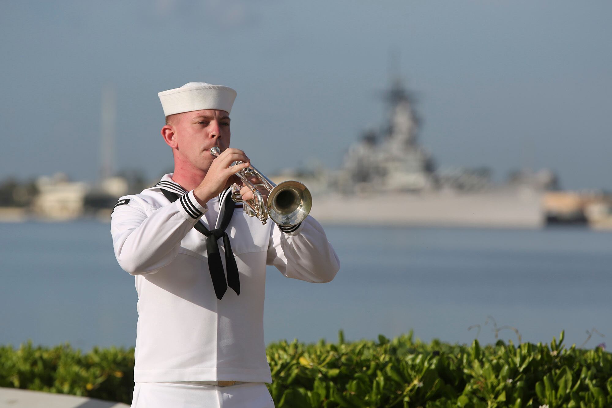 A U.S. Navy sailor plays "Taps" in front of the USS Missouri during a ceremony to mark the anniversary of the attack on Pearl Harbor, Monday, Dec. 7, 2020, in Pearl Harbor, Hawaii.