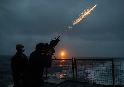 Chief Gunner’s Mate Ricardo Stewart, left, watches as Gunner’s Mate 3rd Class Cullen McArdle fires a flare during a flare exercise in the Philippine Sea aboard the Arleigh Burke-class guided-missile destroyer USS Barry (DDG 52).