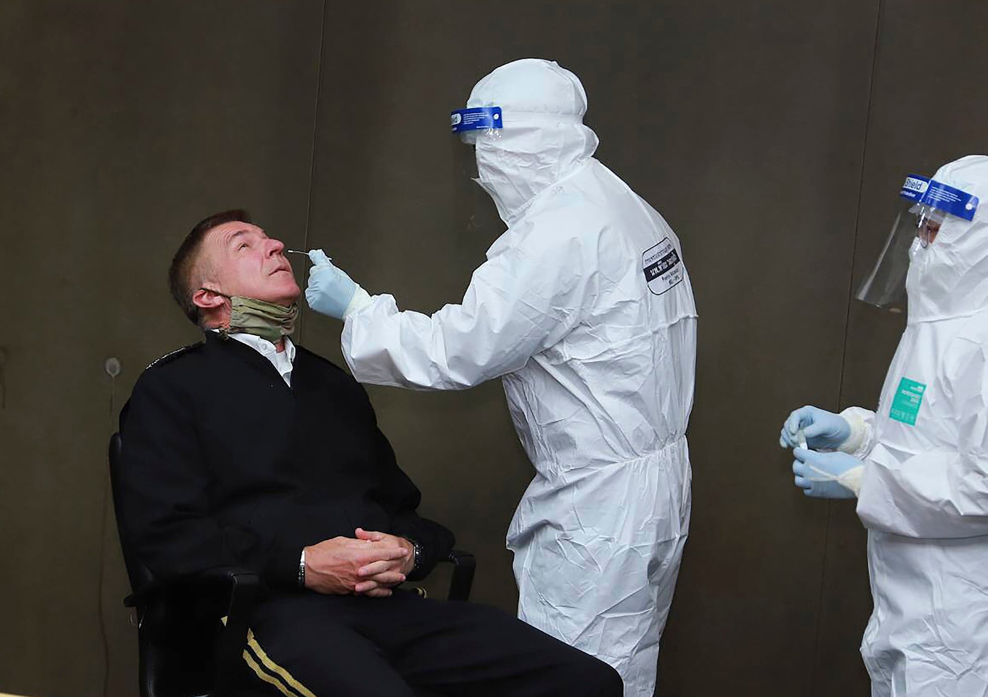 In this photo released by the Royal Thai Army, a health officer collects a nasal swab sample from Gen. James McConville, chief of staff of the U.S. Army, to test for the coronavirus at the military airport in Bangkok on July 9, 2020.