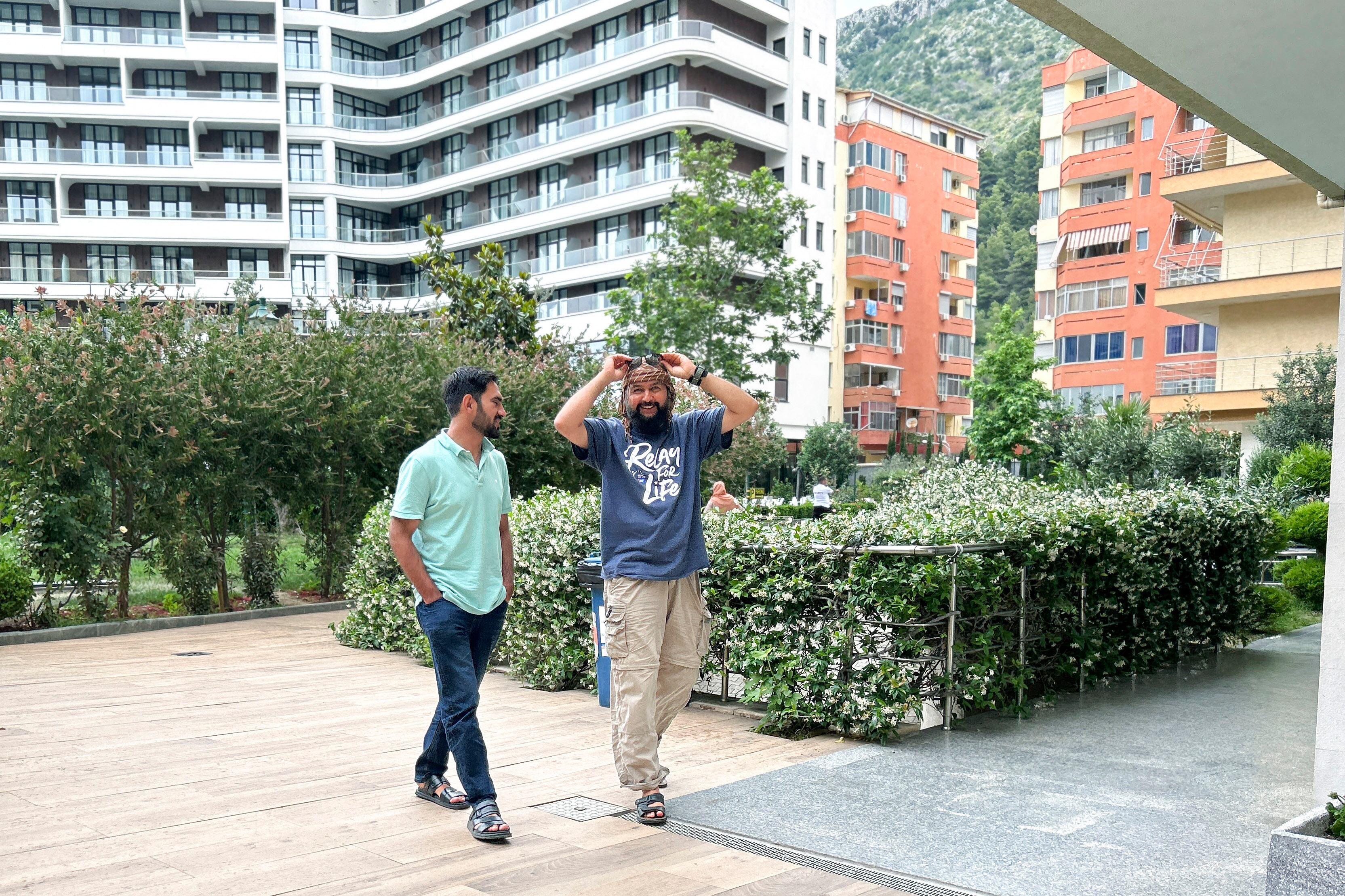 Afghan men walk at a tourist resort where they are accommodated, in Shengjin, 44 miles northwest of the capital, Tirana, Albania, Tuesday, June 6, 2023.