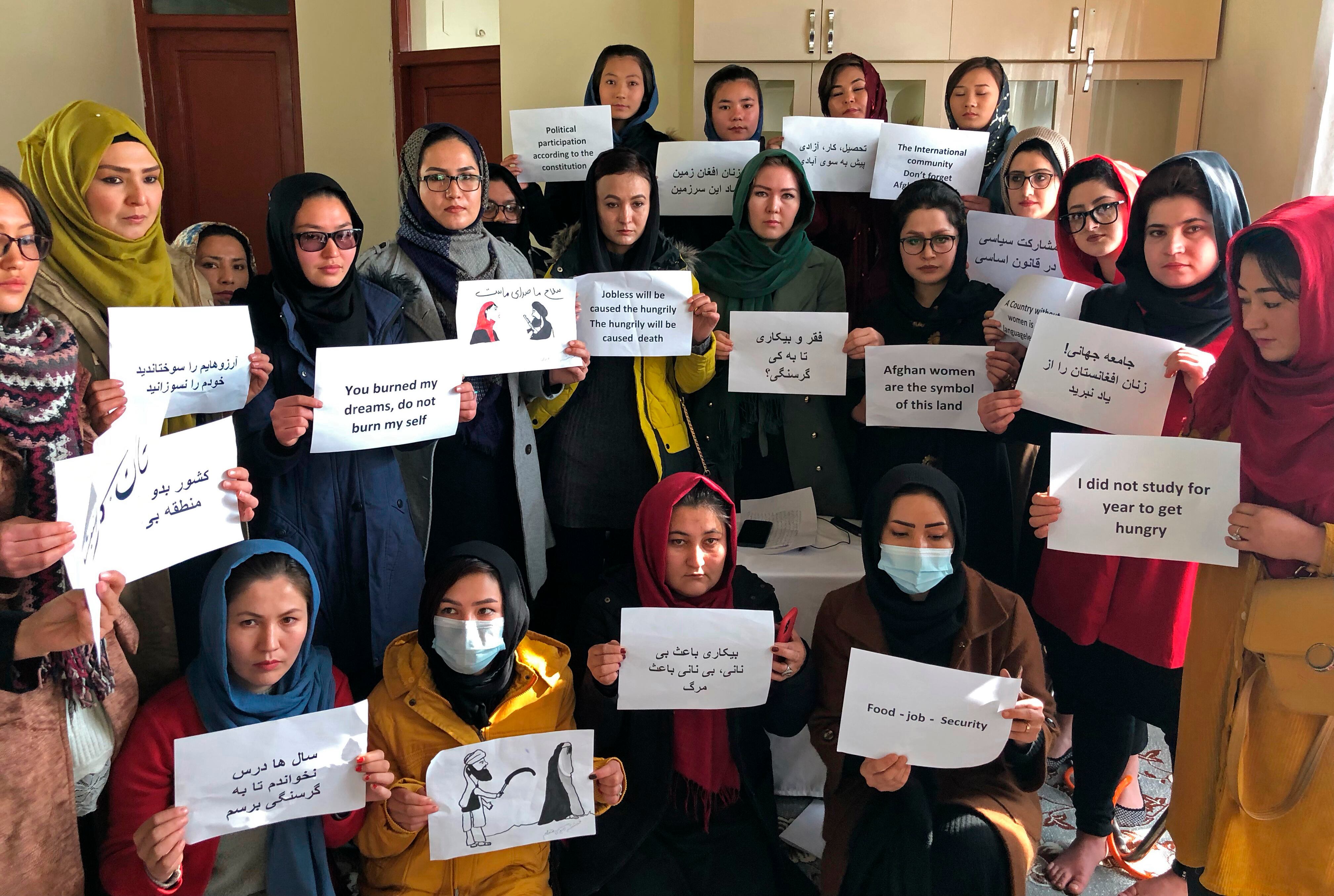 Afghan women chant and hold signs of protest, in Kabul, Afghanistan, Monday, Dec. 27, 2021.