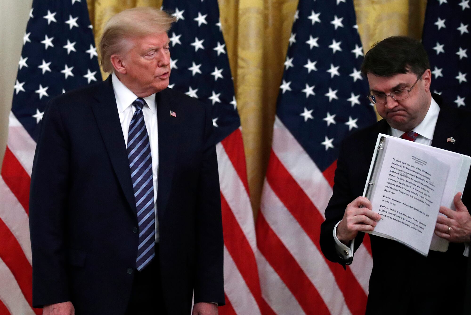 President Donald Trump watches as Veterans Affairs Secretary Robert Wilkie walks away after speaking about protecting seniors, in the East Room of the White House