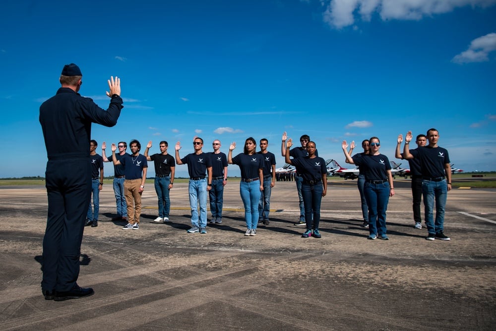 Lt. Col. Noel Colls, flight surgeon for the Air Force's "Thunderbirds" air demonstration squadron, administers the oath of enlistment to new recruits during the Wings Over Houston Airshow in Houston, Texas, Oct. 9, 2021. The team typically performs an enlistment ceremony at each show site. (Staff Sgt. Andrew D. Sarver/Air Force)