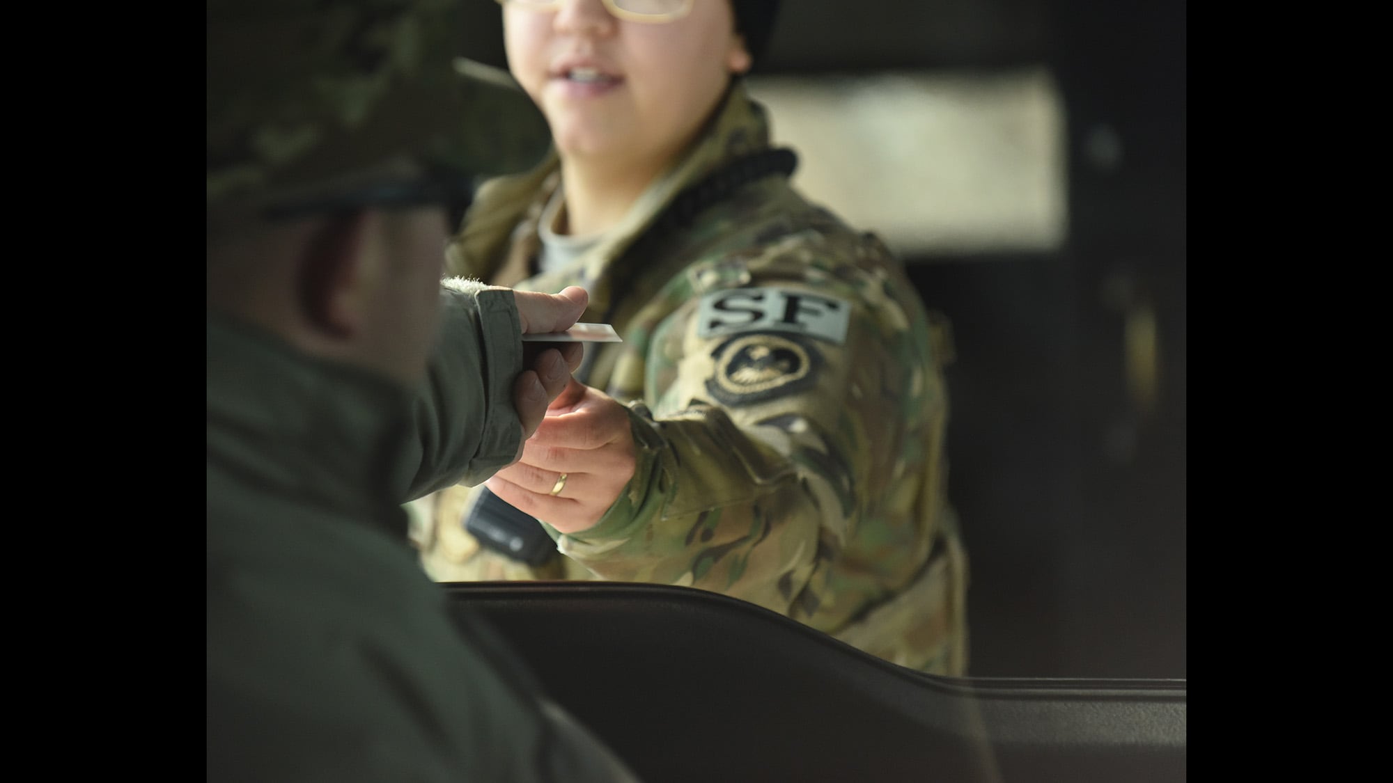 Airman 1st Class Gabriella Sepulveda, a 28th Security Forces Squadron response force member, hands an airman back his common access card after scanning it at the gate to Ellsworth Air Force Base, S.D., Dec. 4, 2018.