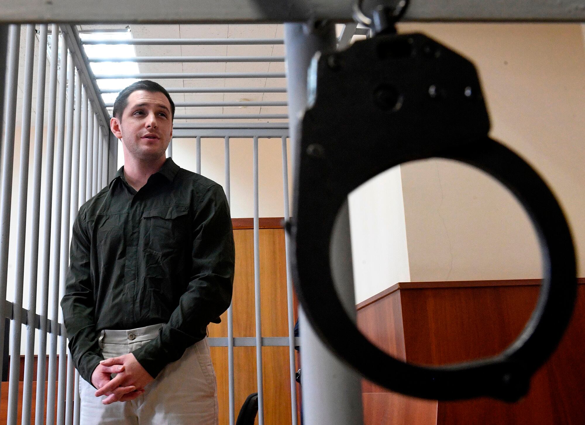 Marine Corps veteran Trevor Reed, charged with attacking police, stands inside a defendants' cage during a court hearing in Moscow on March 11, 2020.