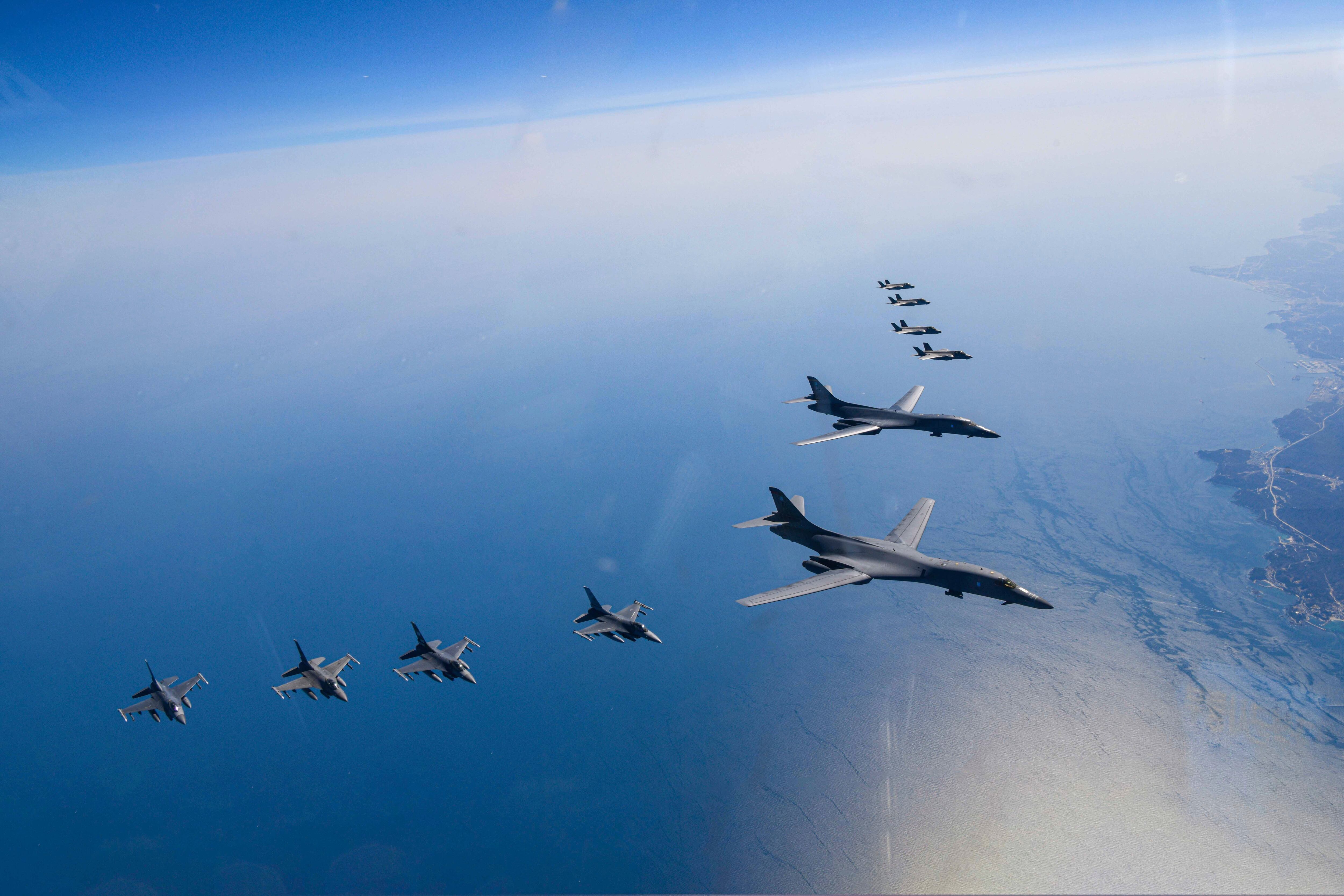 In this photo provided by South Korea Defense Ministry, U.S. Air Force B-1B bombers, center, fly in formation with South Korea's Air Force F-35A fighter jets and U.S. Air Force F-16 fighter jets, bottom left, over the South Korea Peninsula during a joint air drill in South Korea, Sunday, March 19, 2023.