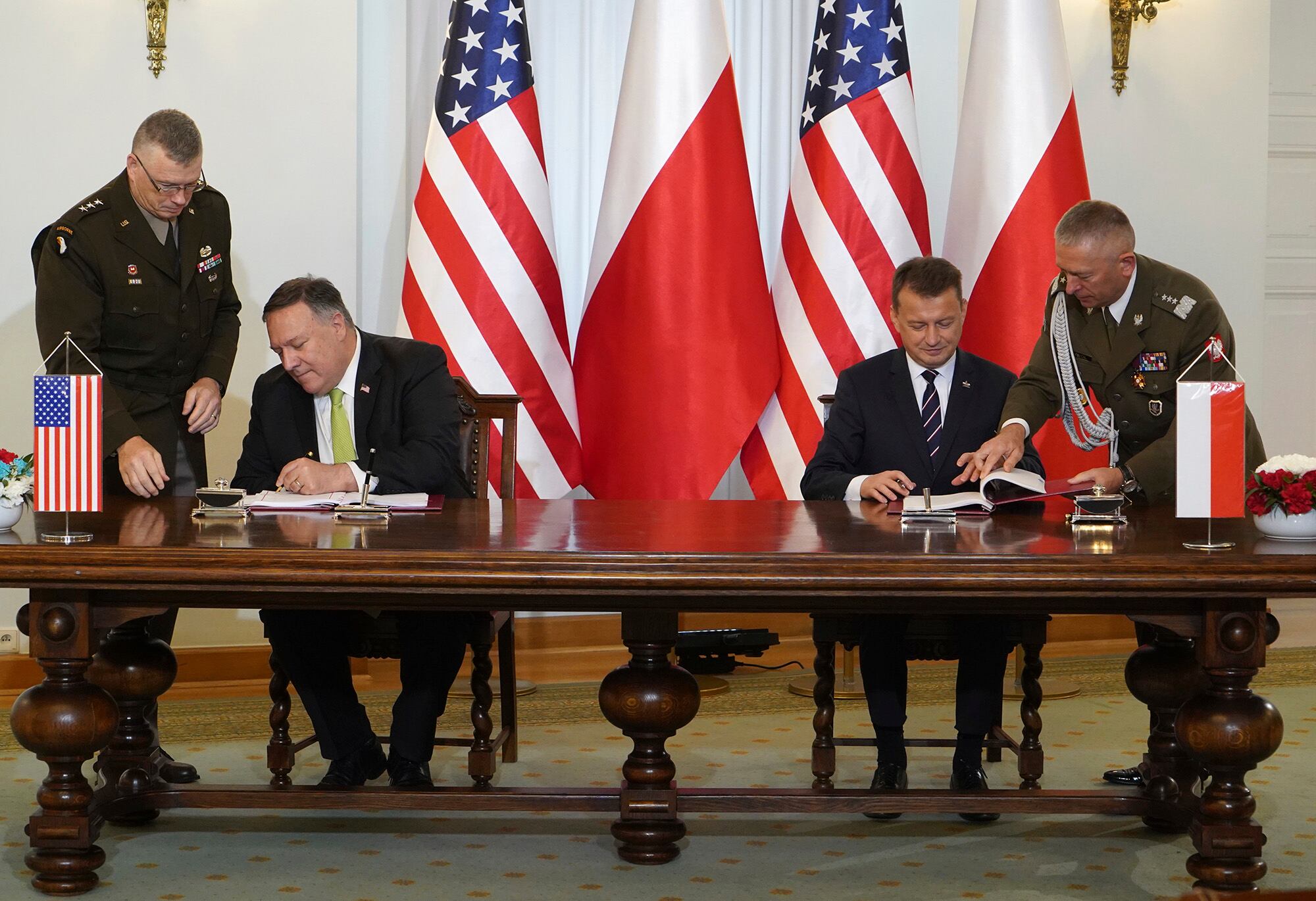 U.S. Secretary of State Mike Pompeo, left, and Poland's Minister of Defence Mariusz Blaszczak sign the U.S.-Poland Enhanced Defence Cooperation Agreement in the Presidential Palace in Warsaw,  Poland, Saturday Aug. 15, 2020.