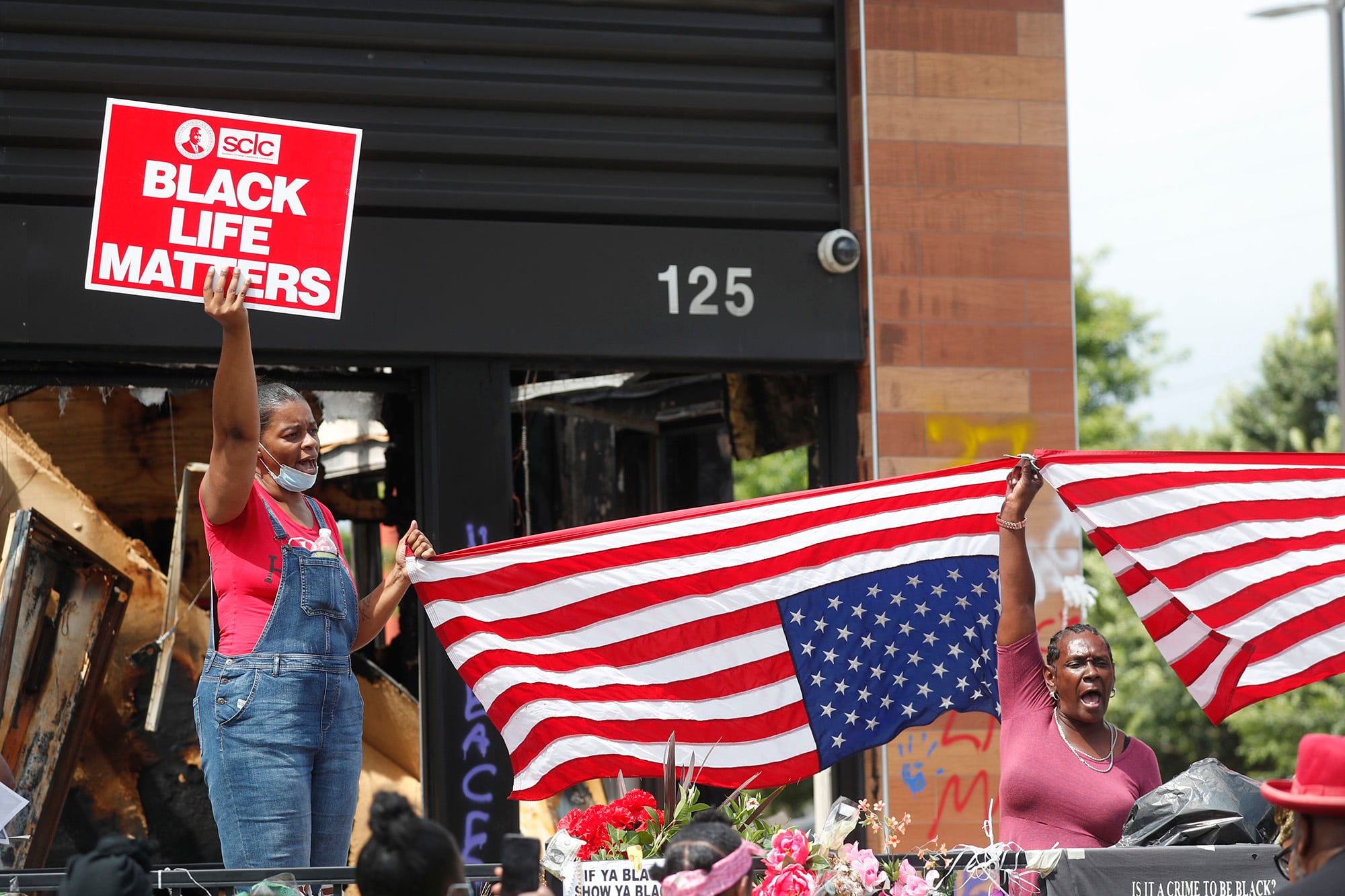 Protesters chant outside a Wendy's restaurant on Tuesday, June 23, 2020, in Atlanta after a funeral for Rayshard Brooks was held. Brooks died after being fatally shot by an Atlanta police officer.