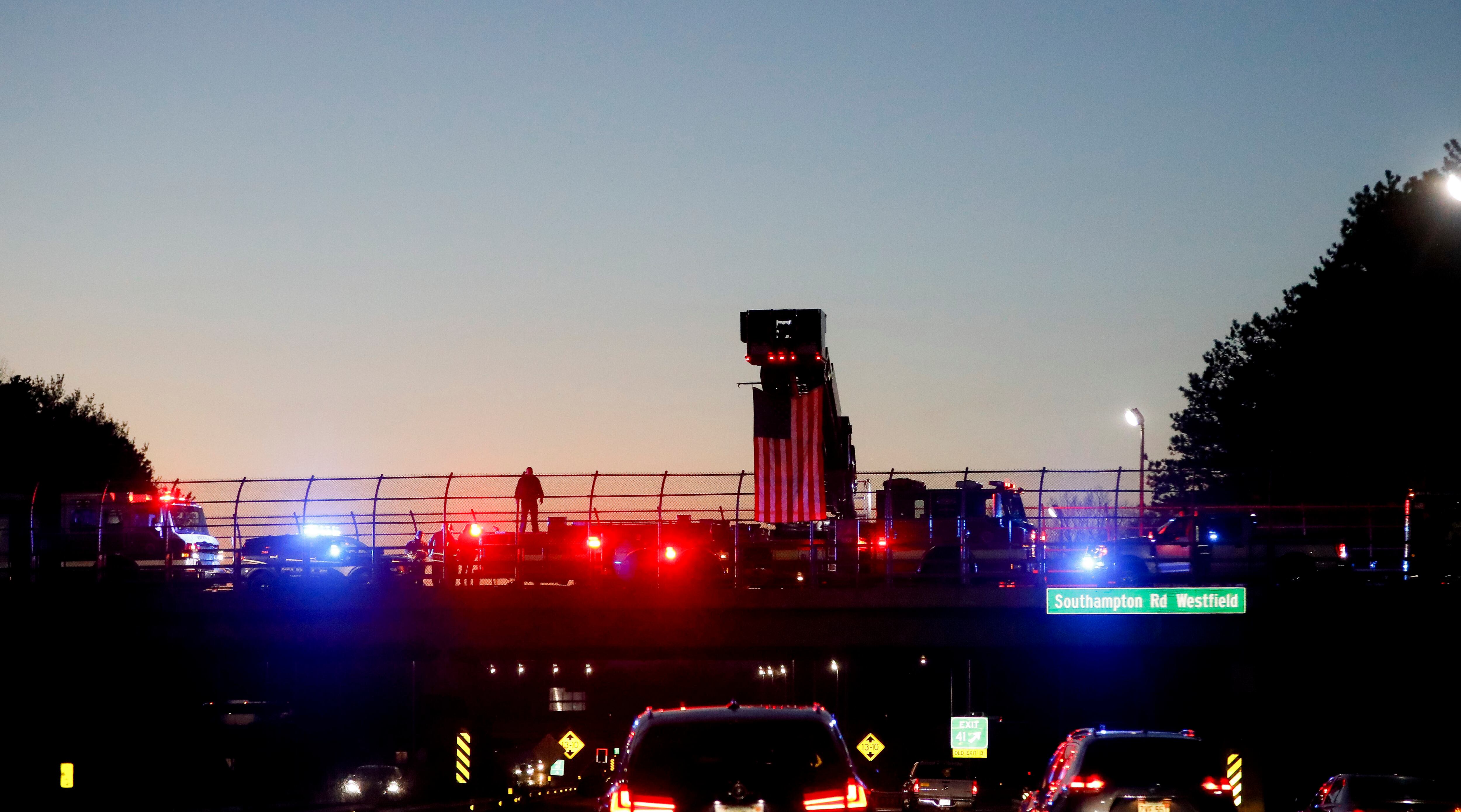 Westfield, Mass., community members and law enforcement gather to pay tribute as a procession leads the casket bearing U.S. Air Force Staff Sgt. Jacob "Jake" Galliher back to Pittsfield, Mass., after landing at Westover Air Reserve Base in Chicopee, Mass., Friday, Dec. 15, 2023.