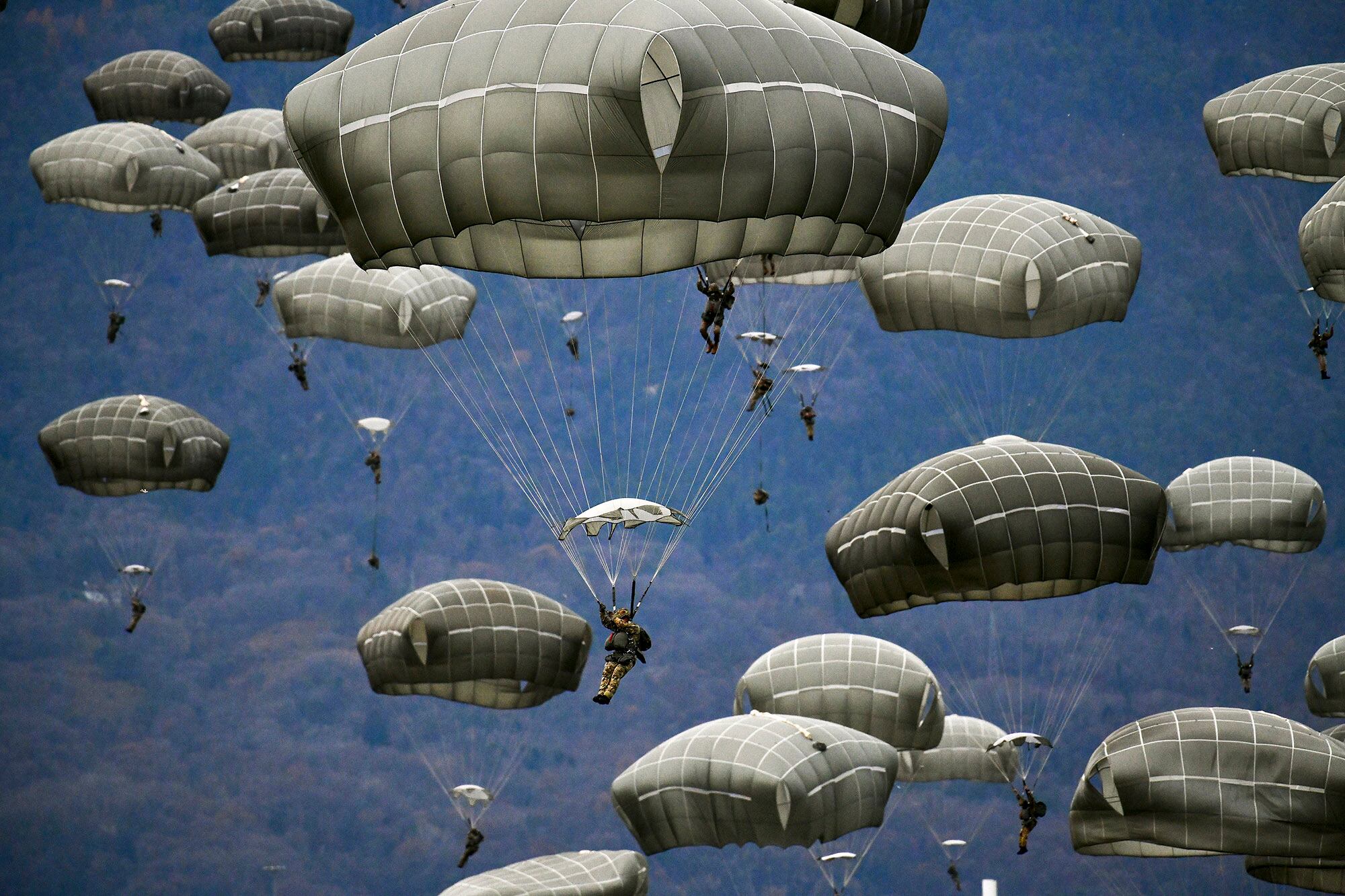 U.S. Army and Italian Army paratroopers conduct airborne operation after exiting a U.S. Air Force C-130 Hercules aircraft at Juliet Drop Zone, Pordenone, Italy, Dec. 10, 2020.