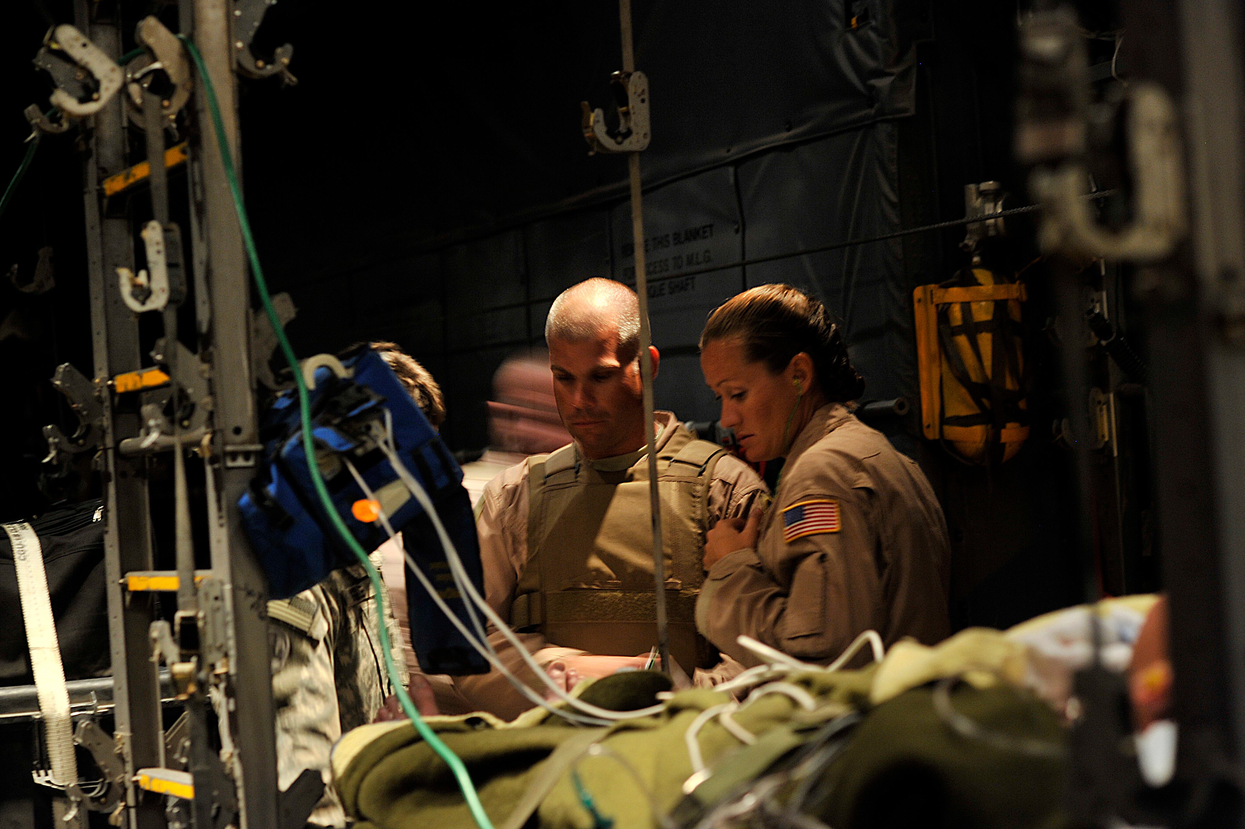 U.S. Air Force Maj. Brandon Bailey, 332nd Expeditionary Operations Support Squadron medical crew director and Tech. Sgt. Kristy Wellman, charge medical technician, evaluate a patient before take off during a "Bandage Mission" on Sept. 23, 2008. Bandage Missions travel to different forward operating bases throughout Iraq and pick up patients and transport them to the Air Force Theater Hospital in Joint Base Balad, Iraq. (Staff Sgt. Aaron Allmon/Air Force)